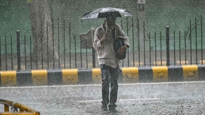 A pedestrian uses an umbrella while crossing a street during rainfall in New Delhi on July 22, 2025. (AFP) A pedestrian uses an umbrella while crossing a street during rainfall in New Delhi on July 22, 2025. (AFP)