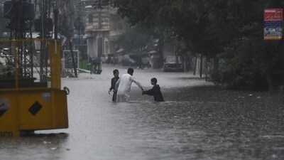 People wade through the flooded street after during the monssoon rain in Rawalpindi, Pakistan on July 17, 2025. (REUTERS)