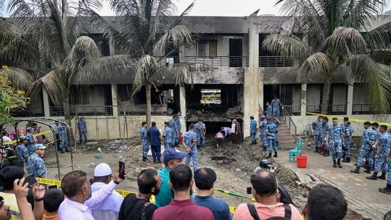Onlookers gathered as Bangladesh Air Force personnel inspect the crash site a day after a training jet crashed into a school in Dhaka on July 22, 2025. (AFP)
