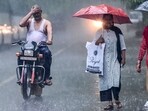 A motorist uses his hands to shield himself from the rain while driving along a road in New Delhi on July 23. A motorist uses his hands to shield himself from the rain while driving along a road in New Delhi on July 23.