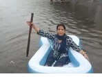 A woman rowing a 'boat' in rainwater in an X post by former Delhi CM Atishi. A woman rowing a 'boat' in rainwater in an X post by former Delhi CM Atishi.