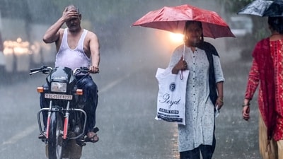 A motorist uses his hands to shield himself from the rain while driving along a road in New Delhi on July 23. (AFP) A motorist uses his hands to shield himself from the rain while driving along a road in New Delhi on July 23. (AFP)