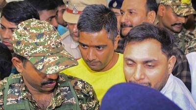 Security personnel escort Chaitanya Baghel (in yellow) after his arrest by the Enforcement Directorate on July 18. (PTI) Security personnel escort Chaitanya Baghel (in yellow) after his arrest by the Enforcement Directorate on July 18. (PTI)