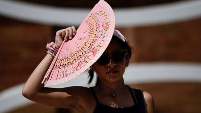 A woman uses a hand-held fan during the summer heat last month in Seville, Spain. A woman uses a hand-held fan during the summer heat last month in Seville, Spain.