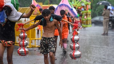 Kanwariyas were carrying the holy water on their shoulders as rain lashed at Noida-Delhi border on 23 July. (Sunil Ghosh / Hindustan Times)