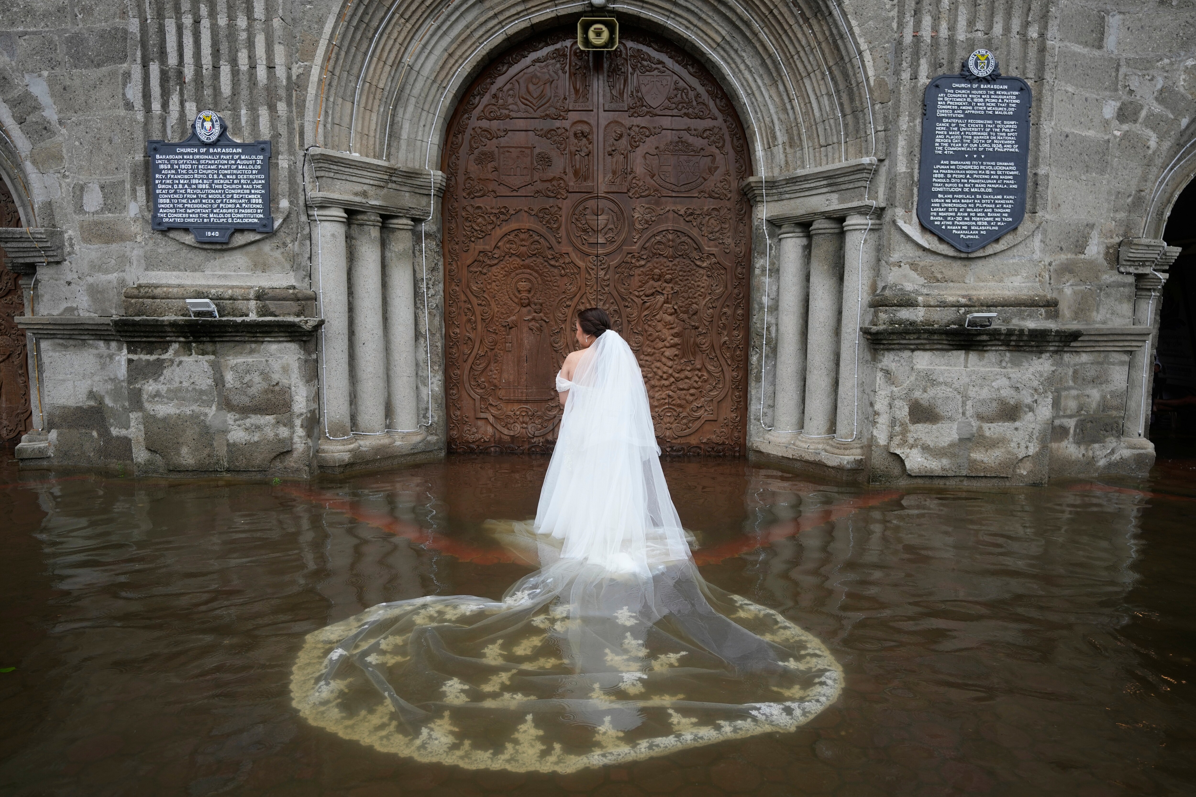 Bride Jamaica Agular prepares to enter the flooded Barasoain church for her wedding in Malolos, Bulacan province, Philippines on Tuesday, July 22, 2025. (AP Photo/Aaron Favila) (AP) Bride Jamaica Agular prepares to enter the flooded Barasoain church for her wedding in Malolos, Bulacan province, Philippines on Tuesday, July 22, 2025. (AP Photo/Aaron Favila) (AP)