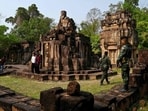 A Thai soldier watches as Cambodian people visit the disputed ancient Khmer temple Prasat Ta Muen Thom on the border in in March 2025. On July 24, hours after the two sides downgraded diplomatic relations in an escalating row over a disputed border, troops exchanged fire in a new round of clashes.