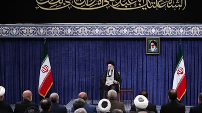 This handout picture released by the office of Iran's Supreme Leader Ayatollah Ali Khamenei shows him hows him waving to the crowd during a meeting with the head of the judiciary and other officials in Tehran on July 16, 2025