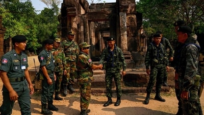 A Cambodian soldier (centre L) shakes hands with a Thai soldier (centre R) at the disputed ancient Khmer temple Prasat Ta Muen Thom, or Prasat Ta Moan Thom in Khmer, on the Cambodian-Thai border in Oddar Meanchey province on March 26, 2025. Cambodian and Thai troops exchanged fire in a new round of clashes on July 24, 2025, hours after the two sides downgraded diplomatic relations in an escalating row over a disputed border. (AFP) A Cambodian soldier (centre L) shakes hands with a Thai soldier (centre R) at the disputed ancient Khmer temple Prasat Ta Muen Thom, or Prasat Ta Moan Thom in Khmer, on the Cambodian-Thai border in Oddar Meanchey province on March 26, 2025. Cambodian and Thai troops exchanged fire in a new round of clashes on July 24, 2025, hours after the two sides downgraded diplomatic relations in an escalating row over a disputed border. (AFP)