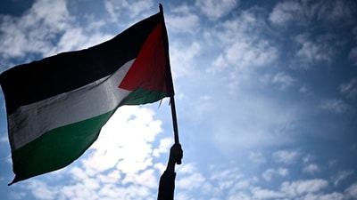 A protester holds a Palestinian flag during a rally called by several French organisations in support of Palestinian people at Place de la Republique in Paris. (AFP File Photo)