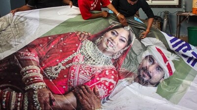 Family members of Raja Raghuvanshi cut out the picture of his wife Sonam Raghuvanshi from a poster of their marriage. (PTI/File) Family members of Raja Raghuvanshi cut out the picture of his wife Sonam Raghuvanshi from a poster of their marriage. (PTI/File)