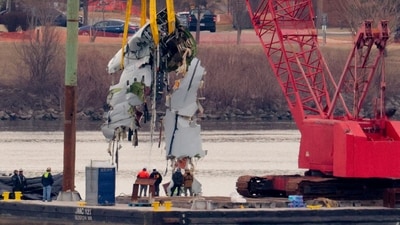 A large portion of the damaged plane fuselage is lifted from the Potomac river during recovery efforts after the American Airlines crash. (Getty Images/AFP) A large portion of the damaged plane fuselage is lifted from the Potomac river during recovery efforts after the American Airlines crash. (Getty Images/AFP)