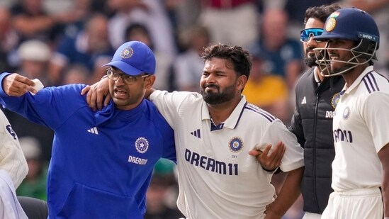Rishabh Pant being assisted by a physio after an injury on day one of the fourth Test. (PTI)