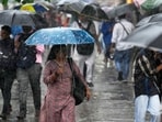 People shelter under umbrellas during a downpour in Mumbai.