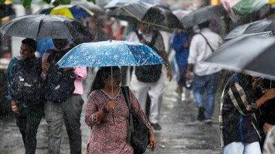 People shelter under umbrellas during a downpour in Mumbai. (AP) People shelter under umbrellas during a downpour in Mumbai. (AP)