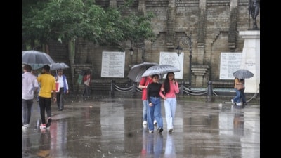 People take stroll with umbrellas during rain at The Ridge, Shimla, on Friday. (Deepak Sansta/ HT)