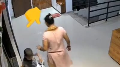 Videograb from viral footage shows the girl seated on the shoe rack with the open window behind her. Videograb from viral footage shows the girl seated on the shoe rack with the open window behind her.