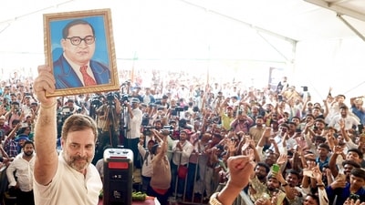 Congress MP Rahul Gandhi, leader of the opposition in Lok Sabha, holds up a picture of BR Ambedkar during a recent event in Darbhanga, Bihar. (ANI File Photo)