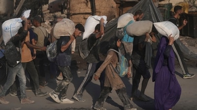 Palestinians carry sacks of flour unloaded from a humanitarian aid convoy that reached Gaza City from the northern Gaza Strip, Saturday. (AP) Palestinians carry sacks of flour unloaded from a humanitarian aid convoy that reached Gaza City from the northern Gaza Strip, Saturday. (AP)