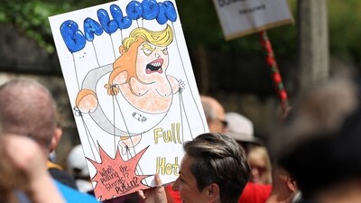 A demonstrator holds a placard during a 'Stop Trump Coalition' protest near the US Consulate building in Edinburgh, Scotland on July 26, 2025. (AFP) A demonstrator holds a placard during a 'Stop Trump Coalition' protest near the US Consulate building in Edinburgh, Scotland on July 26, 2025. (AFP)