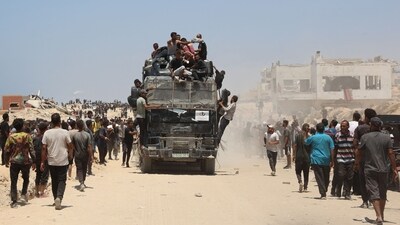 People rush towards an truck carrying humanitarian aid as it drives along al-Rashid street in western Jabalia. (Omar AL-QATTAA/AFP)