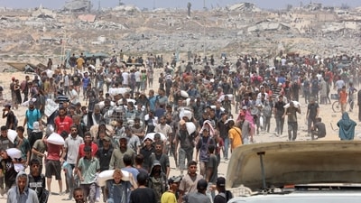 People make their way along al-Rashid street in western Jabalia after receiving humanitarian aid from an aid distribution point in the northern Gaza Strip. The head of Gaza's largest hospital said 21 children have died due to malnutrition and starvation in the Palestinian territory in the past three days, while Israel pressed a devastating assault. (Omar AL-QATTAA/AFP)