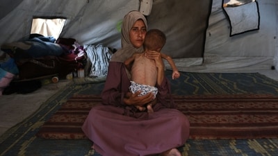 Hidaya, a 31-year-old Palestinian mother, cradles her sick 18-month-old son Mohammed al-Mutawaq, who is also displaying signs of malnutrition, inside their tent at the Al-Shati refugee camp, west of Gaza City. More than 100 aid organisations and human rights groups warned that mass starvation was spreading in Gaza, as the United States said its top envoy was heading to Europe for talks on a possible ceasefire and aid corridor. (Omar AL-QATTAA/AFP)