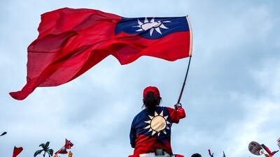 A supporter of Taiwan's main opposition party, Kuomintang (KMT), waves the country's national flag during a rally against the recall election in front of the Presidential Office in Taipei (AFP)