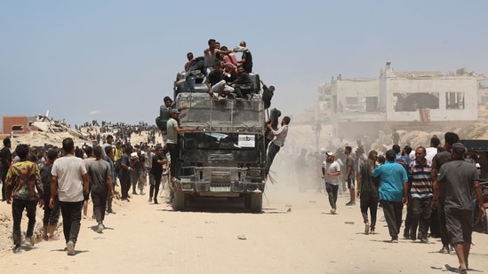People rush towards an truck carrying humanitarian aid as it drives along al-Rashid street in western Jabalia.(Omar AL-QATTAA/AFP)