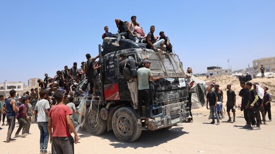 People rush towards an truck carrying humanitarian aid as it drives along al-Rashid street in western Jabalia after trucks entered the northern Gaza Strip through the Israeli-controlled Zikim border crossing.(Omar AL-QATTAA/AFP)