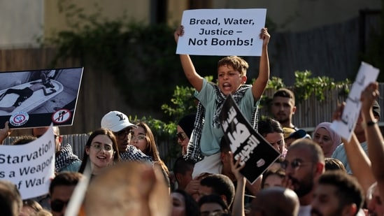 A young boy raises a placard as he takes part in a protest in the Arab-Israeli town of Sakhnin on July 25, 2025, to denounce the shortage of food in the Gaza Strip and the ongoing Israeli onslaught.(AFP)