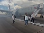 Videos circulating online show visibly panicked passengers sliding down evacuation chutes and running away from the plane