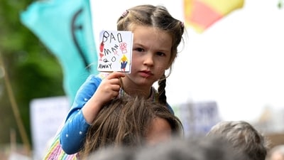 A child holds a placard as anti-Trump demonstrators gather during a rally organised by the campaign group Stop Trump Coalition, protesting the visit of U.S. President Donald Trump, in Edinburgh, Scotland, Britain, July 26, 2025. REUTERS/Lesley Martin     TPX IMAGES OF THE DAY (REUTERS)