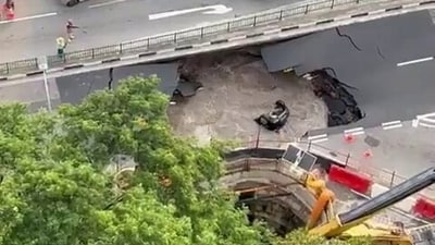 A car plunged into a large, water-filled sinkhole in Singapore on July 26. A car plunged into a large, water-filled sinkhole in Singapore on July 26.