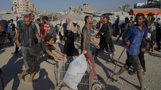 Palestinians carry sacks of flour unloaded from a humanitarian aid convoy that reached Gaza City from the northern Gaza Strip, Saturday, July 26, 2025. (AP)