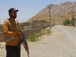 A security personnel stands guard along a street near the site of a school bus bombing in the Khuzdar district of Balochistan province.