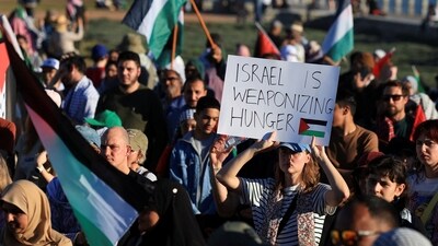 A pro-Palestinian activist holds a placard as they protest over hunger crisis in Gaza, along Sea Point Promenade in Cape Town, South Africa. (REUTERS)
