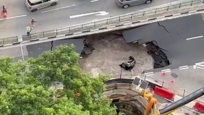 A car plunged into a large, water-filled sinkhole in Singapore on July 26. A car plunged into a large, water-filled sinkhole in Singapore on July 26.