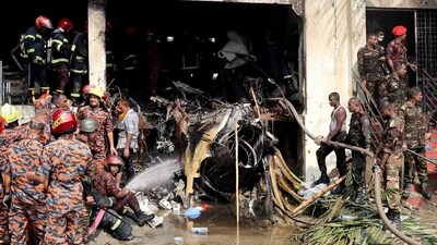 Firefighters and army members work next to the wreckage of an air force training aircraft after it crashed into Milestone College campus, in Dhaka, Bangladesh (REUTERS)