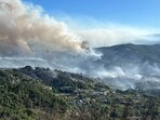 Smoke from a wildfire rises over the hills near the village of Canelas, Arouca region, Portugal