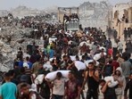 Palestinians crowd a coastal path west of Beit Lahia after managing to get aid parcels on July 29, 2025, following the entry of aid trucks to the Israel-besieged Gaza Strip.