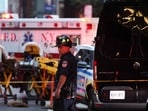 A firefighter stands near emergency vehicles as police respond to a nearby shooting incident in the Midtown Manhattan neighborhood of New York on July 28, 2025. (Photo by CHARLY TRIBALLEAU / AFP)