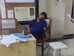 The screengrab from the video shows a doctor reclining with their legs up in front of an air conditioner, visibly asleep.