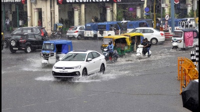 Commuters make their way through the rain in Lucknow on Tuesday. (Deepak Gupta/HT Photo)
