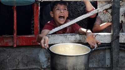 A Palestinian reacts as he waits to receive food from a charity kitchen, amid a hunger crisis, in Gaza City, on July 28, (REUTERS)
