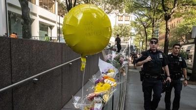 New York City police officers walk past flowers placed outside the midtown office building where a gunman killed four people on July 29, 2025 in New York City. (Getty Images via AFP) New York City police officers walk past flowers placed outside the midtown office building where a gunman killed four people on July 29, 2025 in New York City. (Getty Images via AFP)