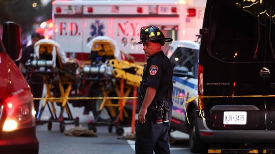 A firefighter stands near emergency vehicles as police respond to a nearby shooting incident in the Midtown Manhattan neighborhood of New York on July 28, 2025. (Photo by CHARLY TRIBALLEAU / AFP) (AFP)