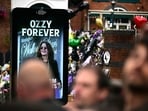 A close up shot of a billboard honouring the heavy metal hell-raiser that reads “Ozzy Forever”, on a street in Birmingham lined with mourners and music fans.