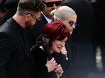 The family of Ozzy Osbourne, son Jack Osbourne, widow Sharon Osbourne (C) and daughter Kelly Osbourne arrive to lay flowers at the Black Sabbath Bridge bench on Broad Street during a funeral procession for Ozzy Osbourne. (Photo by Ben STANSALL / AFP) The family of Ozzy Osbourne, son Jack Osbourne, widow Sharon Osbourne (C) and daughter Kelly Osbourne arrive to lay flowers at the Black Sabbath Bridge bench on Broad Street during a funeral procession for Ozzy Osbourne. (Photo by Ben STANSALL / AFP)