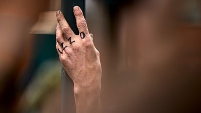 A fan with the word 'OZZY' written on their hand, stands on a street lined with mourners and fans, echoing the rockstar's own hand tattoo which also says ‘OZZY’. (Ben STANSALL/AFP) A fan with the word 'OZZY' written on their hand, stands on a street lined with mourners and fans, echoing the rockstar's own hand tattoo which also says ‘OZZY’. (Ben STANSALL/AFP)